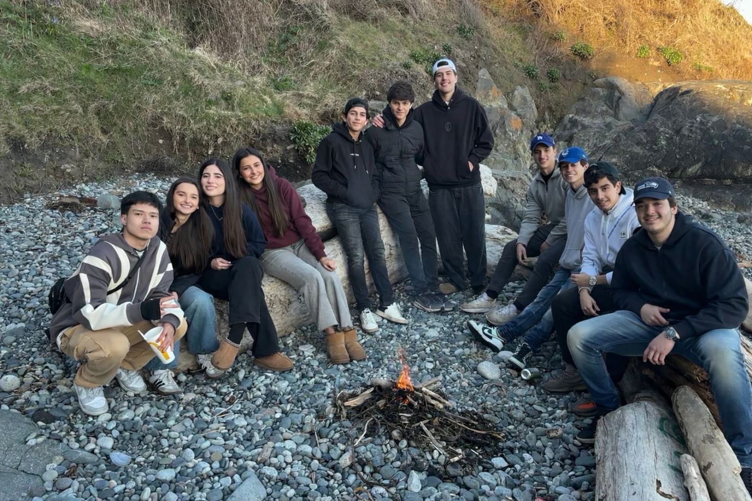 Grupo de intercambistas Best em fogueira na praia